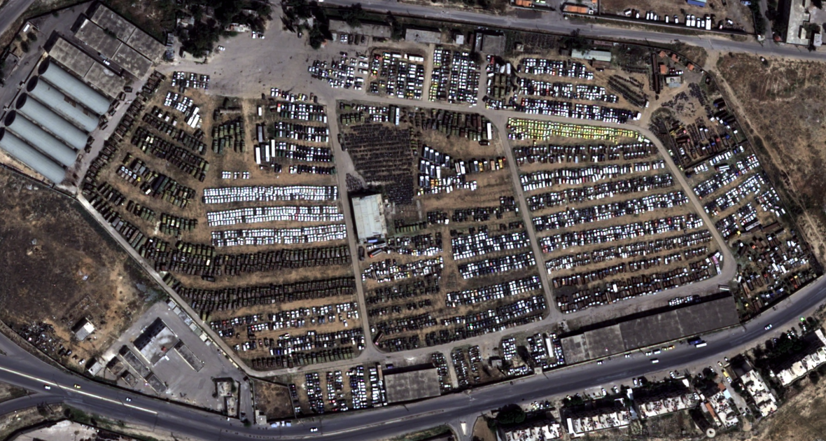Satellite image of a large car park with hundreds of vehicles.