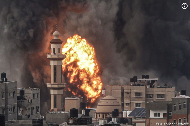 Ein Feuerball nach einem Luftangriff steigt hinter einem Minarett im Gazastreifen auf.