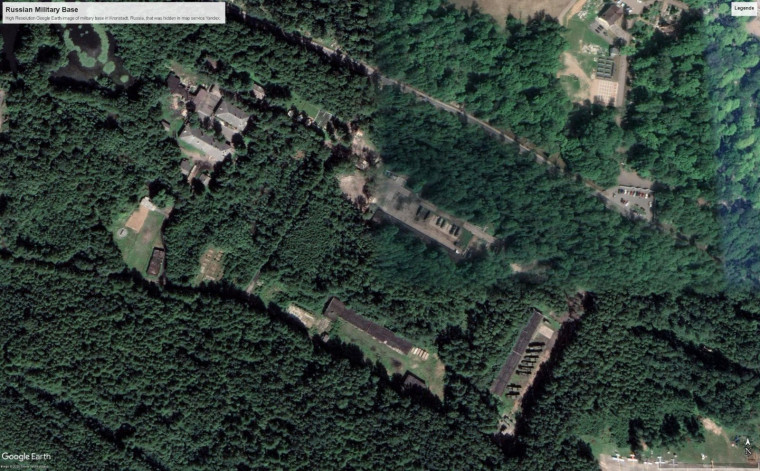Google-Earth-Bild desselben Ortes: Zwischen den Bäumen sind Gebäude und längliche Anlagen der Raketenstellung zu sehen.