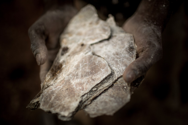 Zwei Hände halten einen großen Brocken des Minerals Glimmer.