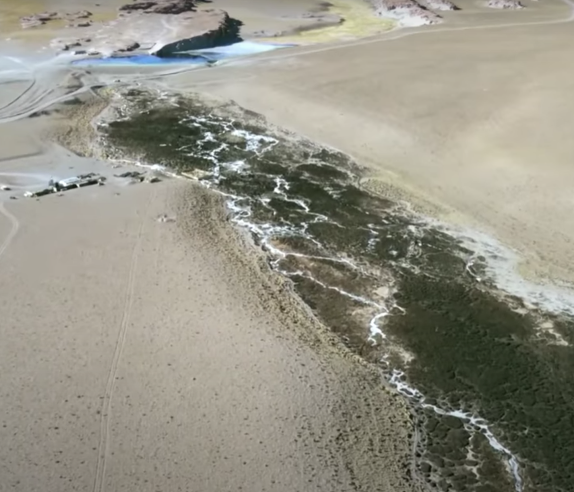 Luftaufnahme eines Salzsees mit Wasserlauf in den Anden.
